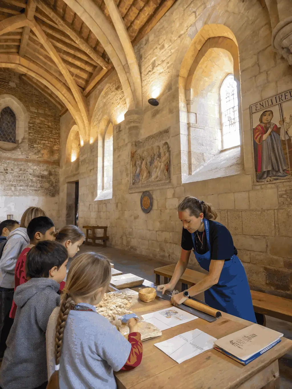 A group of local school children and volunteers participating in an educational workshop inside the chapel, surrounded by historical artifacts and learning materials.